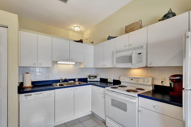 kitchen with backsplash, white appliances, sink, and white cabinetry