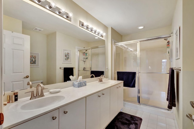 bathroom with a shower with door, toilet, vanity with extensive cabinet space, tile floors, and dual sinks