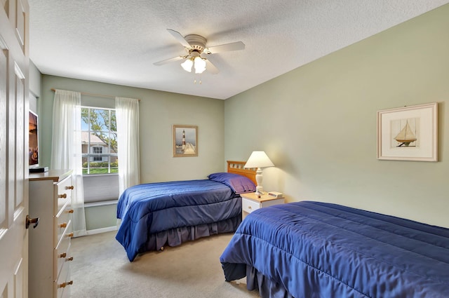 carpeted bedroom featuring a textured ceiling and ceiling fan