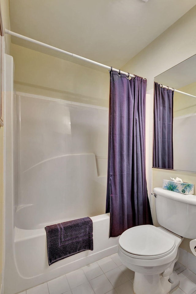 bathroom with shower / bath combination with curtain, tile floors, and toilet