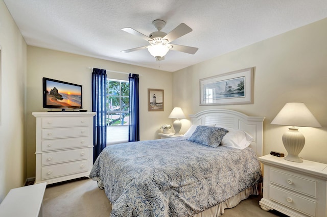 bedroom featuring light colored carpet, ceiling fan, and a textured ceiling