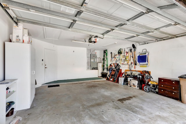 garage featuring water heater, a workshop area, and a garage door opener