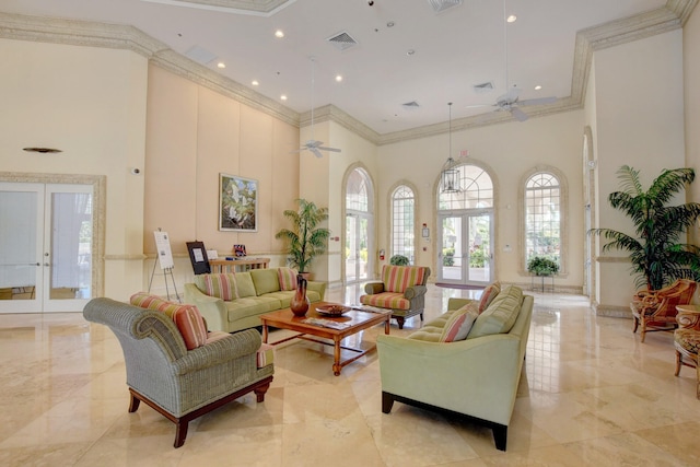 tiled living room featuring ceiling fan, crown molding, french doors, and a high ceiling