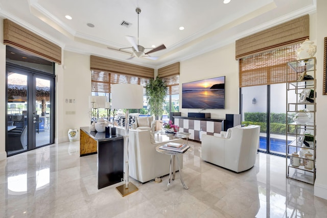 living room featuring crown molding, ceiling fan, light tile floors, and a raised ceiling