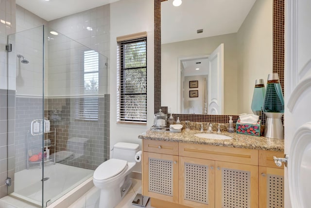 bathroom featuring walk in shower, vanity, toilet, and tile floors