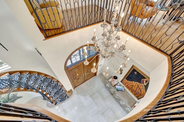 foyer entrance featuring a high ceiling, a chandelier, and tile floors