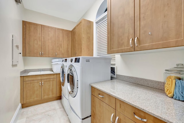 washroom with cabinets, sink, light tile floors, and washer and clothes dryer