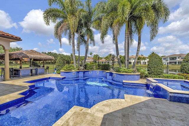 view of swimming pool with a bar and an in ground hot tub