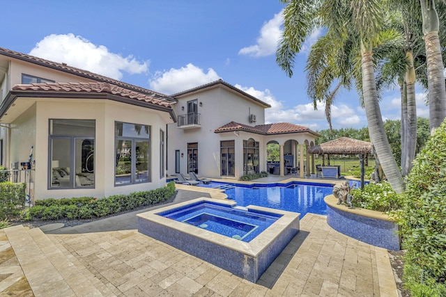 view of pool with a patio and an in ground hot tub