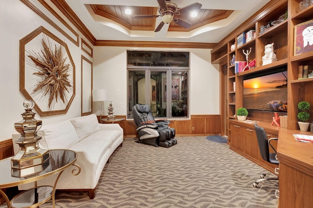 living area featuring a tray ceiling, ceiling fan, carpet, and crown molding