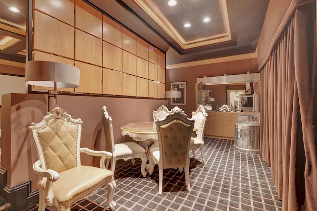 carpeted dining room featuring a tray ceiling and ornamental molding