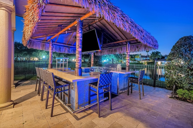 patio terrace at night with a grill and a bar