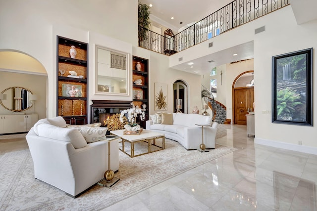 living room with a towering ceiling and light tile floors