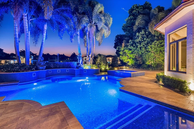 pool at dusk featuring an in ground hot tub