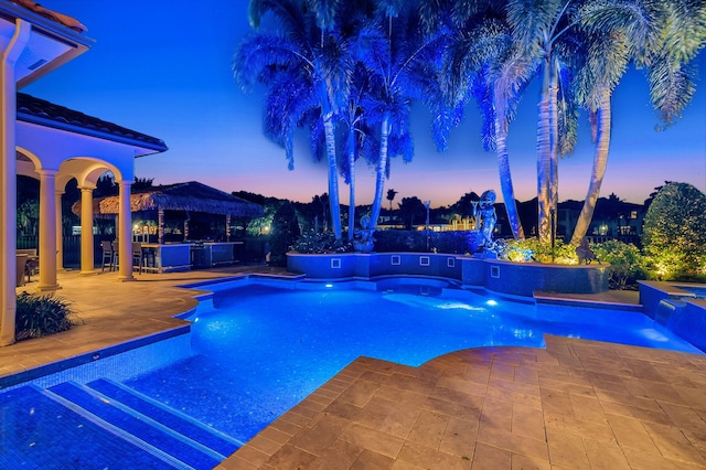 pool at dusk with a patio