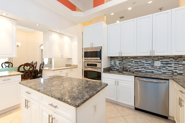 kitchen featuring a center island, sink, white cabinets, and appliances with stainless steel finishes