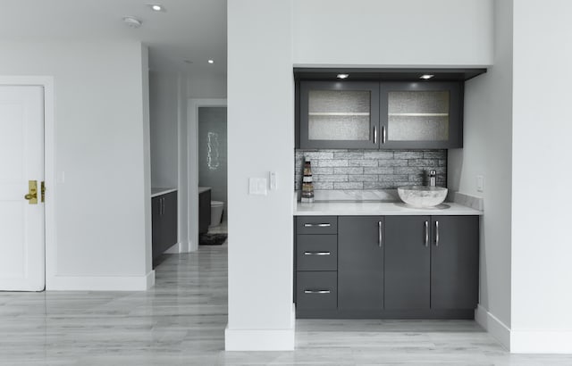 bar featuring sink and tasteful backsplash