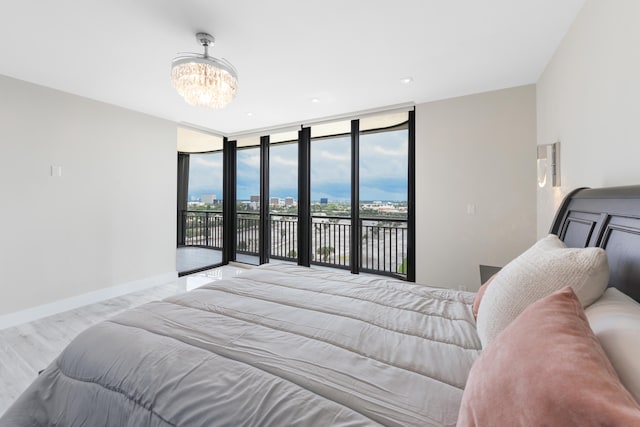 bedroom featuring a chandelier, expansive windows, and access to exterior