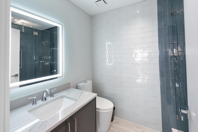 bathroom with hardwood / wood-style floors, toilet, and vanity