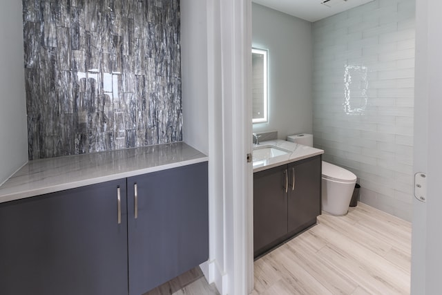 bathroom with oversized vanity, tile walls, and toilet