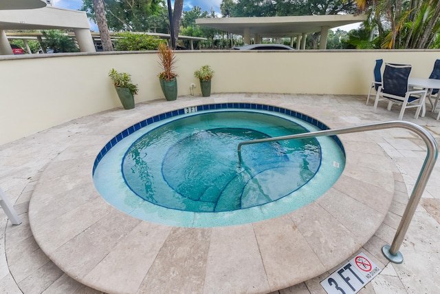 view of swimming pool with a hot tub and a patio