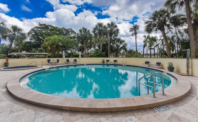 view of swimming pool featuring a hot tub