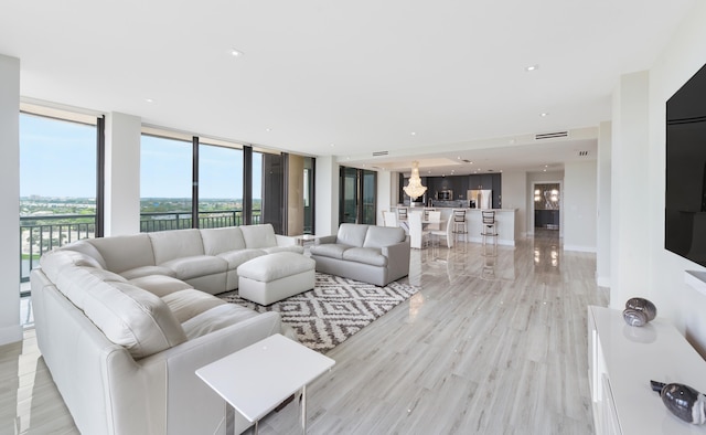 living room with floor to ceiling windows and light hardwood / wood-style floors