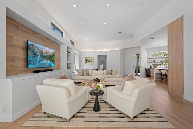 living room with light hardwood / wood-style flooring and built in shelves