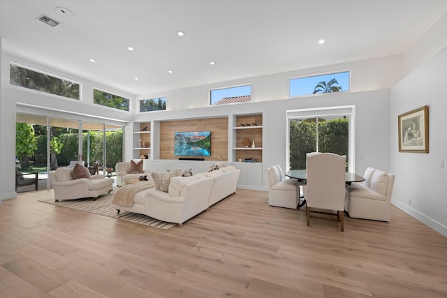 living room featuring hardwood / wood-style flooring, plenty of natural light, and a high ceiling