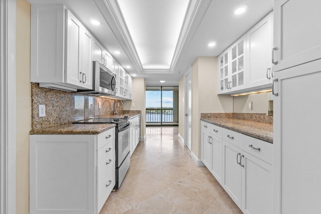 kitchen featuring white cabinetry, appliances with stainless steel finishes, and dark stone counters