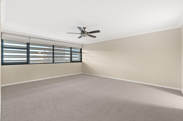 carpeted spare room featuring crown molding and ceiling fan