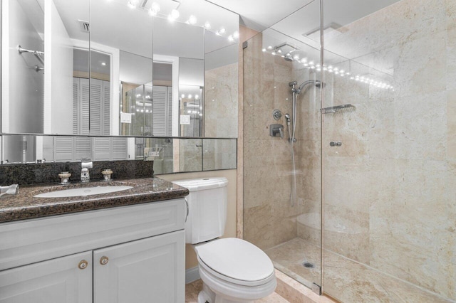 bathroom with vanity, a shower with shower door, and toilet