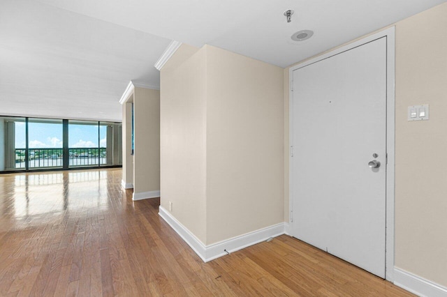 interior space with crown molding, wood-type flooring, and floor to ceiling windows