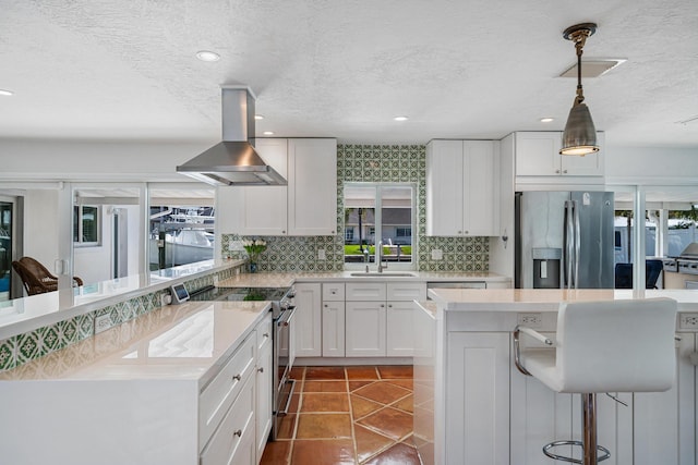 kitchen with plenty of natural light, stainless steel appliances, white cabinets, and island exhaust hood