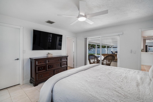 tiled bedroom with access to outside, a textured ceiling, and ceiling fan