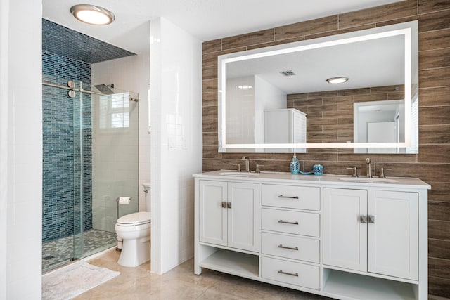 bathroom with tile patterned floors, toilet, an enclosed shower, tile walls, and vanity