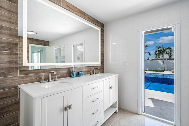 bathroom with tile walls, vanity, and tile patterned flooring