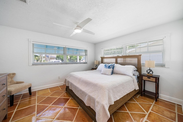 tiled bedroom with a textured ceiling and ceiling fan