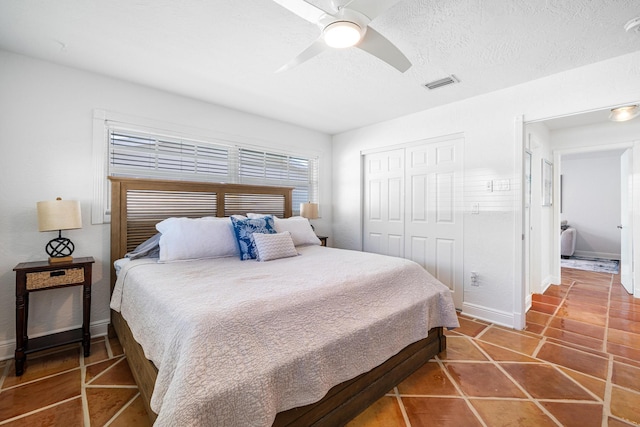 bedroom featuring ceiling fan, a closet, and a textured ceiling