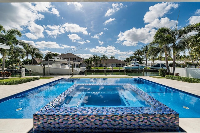 view of swimming pool with a water view and an in ground hot tub