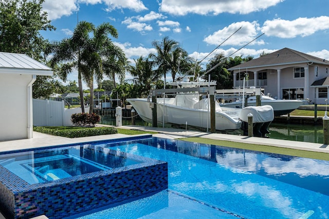 view of pool with a dock and an in ground hot tub