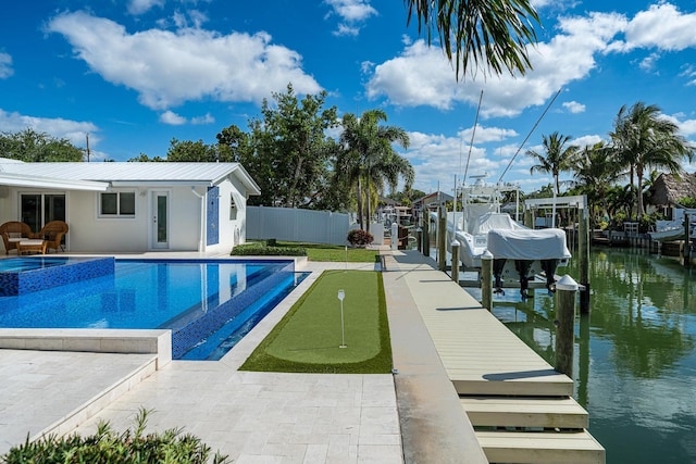 view of pool with a water view, an in ground hot tub, a patio, and a boat dock