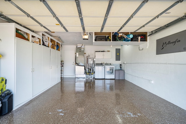 garage featuring heating unit, a garage door opener, electric panel, and independent washer and dryer