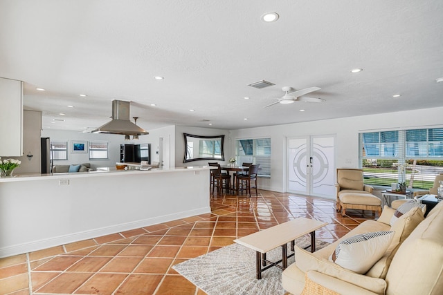 tiled living room featuring ceiling fan and a textured ceiling