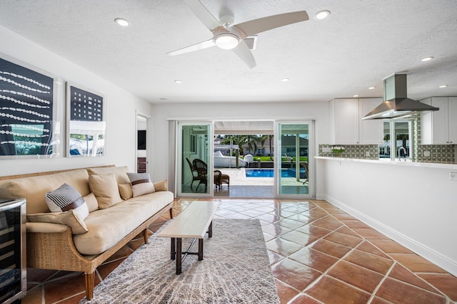 living room featuring tile patterned flooring, sink, a wealth of natural light, and a textured ceiling