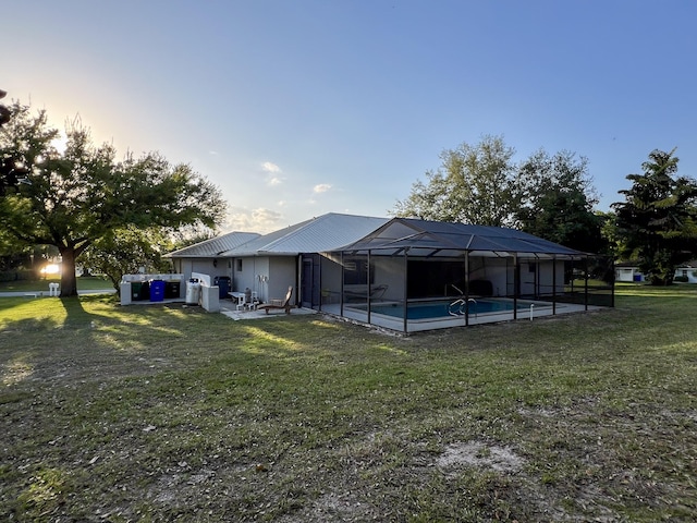 back of property featuring a patio area, a yard, and glass enclosure