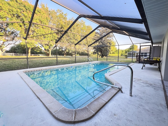 view of pool with a patio area, a yard, and glass enclosure