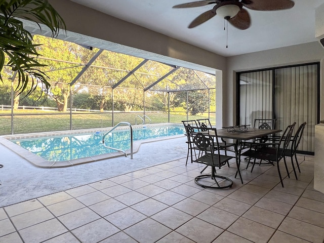 view of swimming pool featuring a patio, glass enclosure, a yard, and ceiling fan