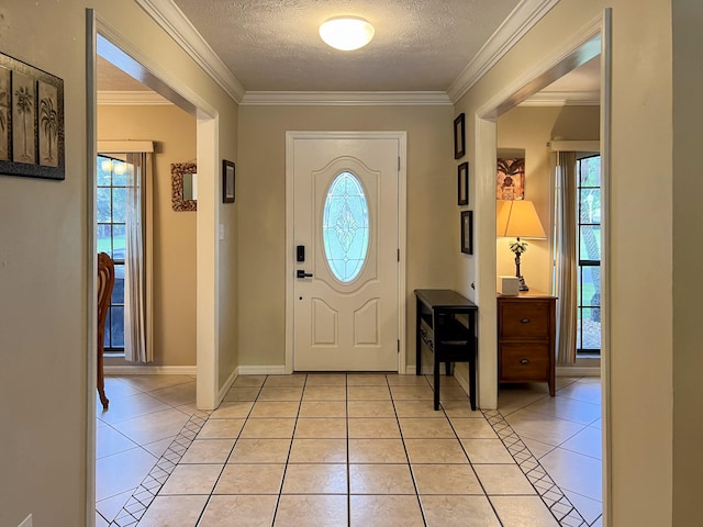 tiled foyer with ornamental molding and a textured ceiling