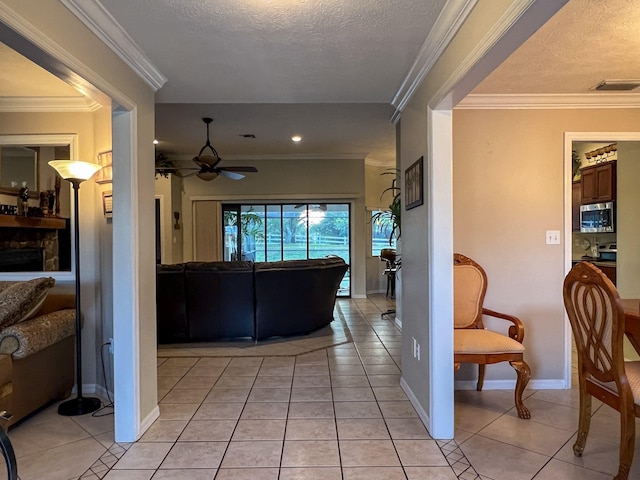 hallway with a textured ceiling, light tile flooring, and ornamental molding